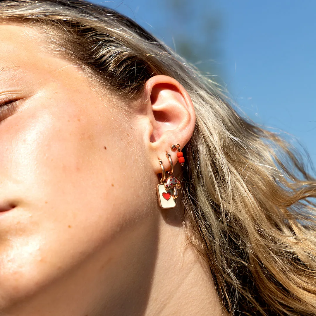 Rose gold coloured/red hoop earring with a mushroom charm